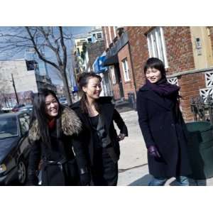  Three Young Asian Women Walk Down a City Stree Conversing 