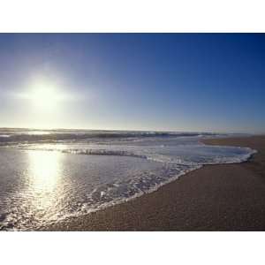  Gentle Waves Lap Onto a Pristine Sandy Beach with the Sun 