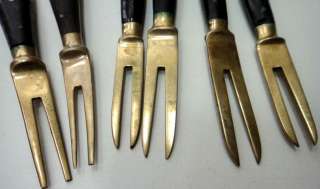  forks most likely that are brass with wood handles and brass tips