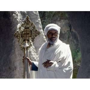 Old Ethiopian Orthodox Priest Holds a Large Brass Coptic Cross at Rock 