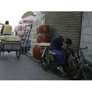  Man Delivers Goods Via a Bicycle Cart While Another Rests 